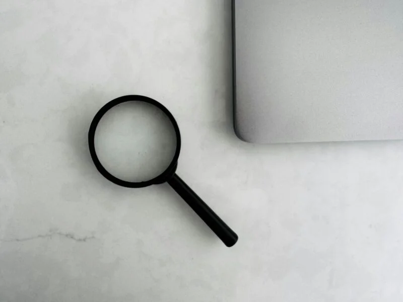 Magnifying glass on a laptop representing AI search and SEO research