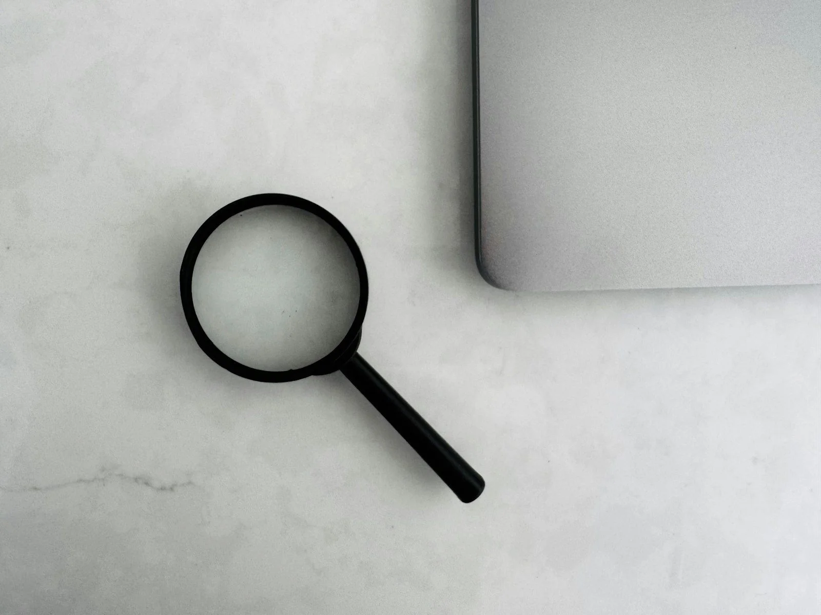 Magnifying glass on a laptop representing AI search and SEO research