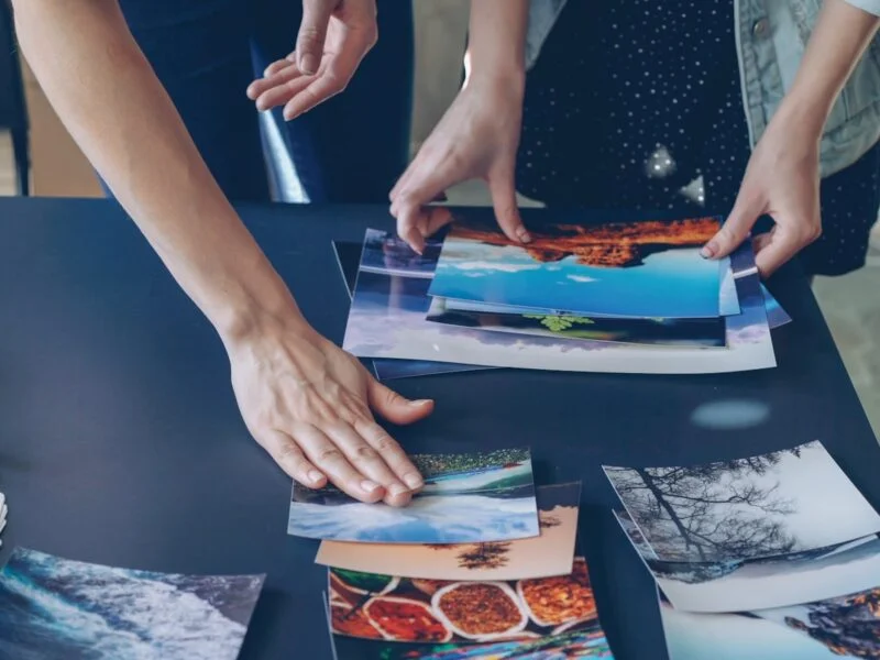 People arranging photos representing image SEO and visual content workflow