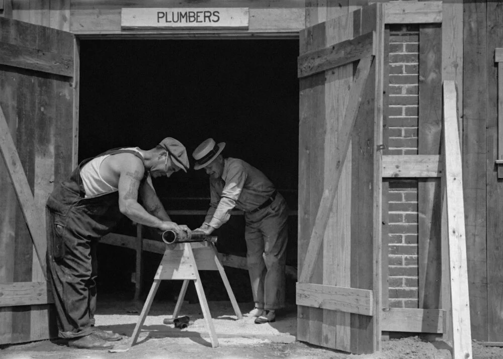 Plumber working on pipes representing local SEO for plumbing businesses