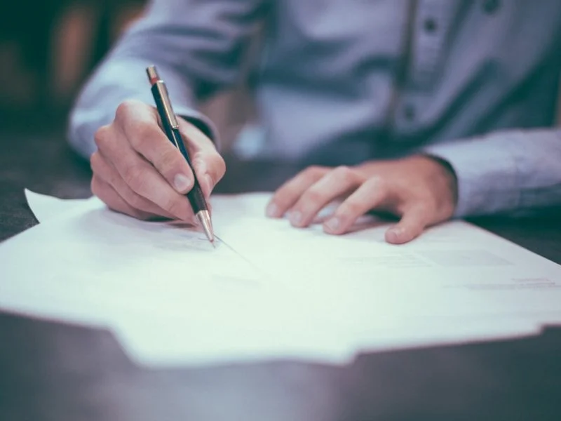 Person writing optimised meta descriptions for search results