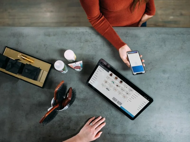 Shopper holding a phone with an online cart open, hesitating before completing a purchase