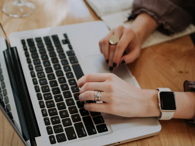 Small business owner reviewing a website design and budget notes on a laptop at a desk