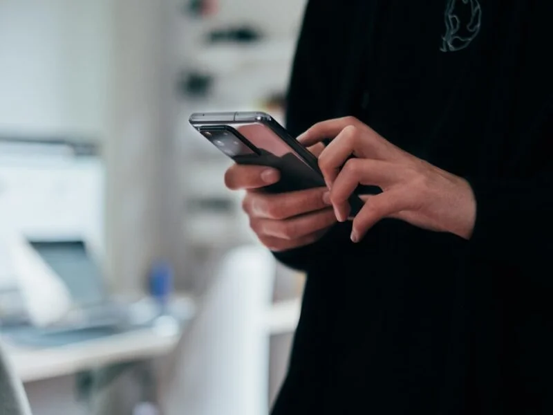 Person asking an AI assistant on a phone for a business recommendation
