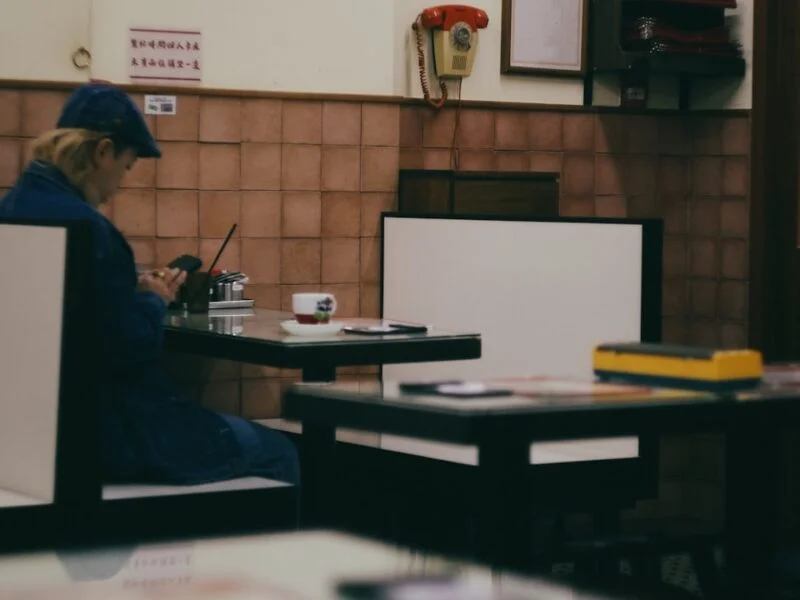 Diner using a phone to book a table on a restaurant website in a warmly lit cafe