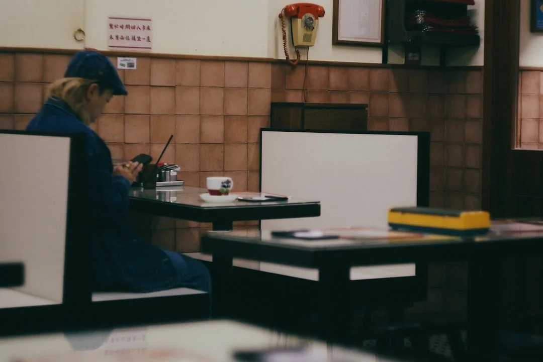 Diner using a phone to book a table on a restaurant website in a warmly lit cafe