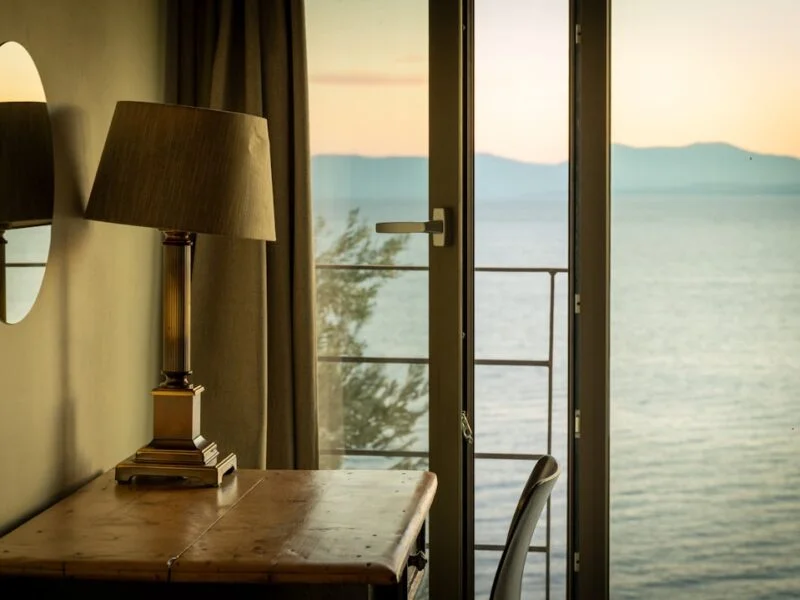 Sunlit coastal holiday let bedroom with a sea view, styled for guests booking a Sussex seaside stay