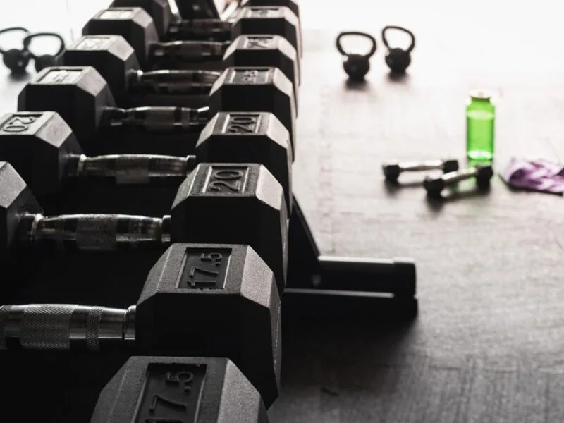 A gym member checking a class timetable on their phone inside a bright fitness studio
